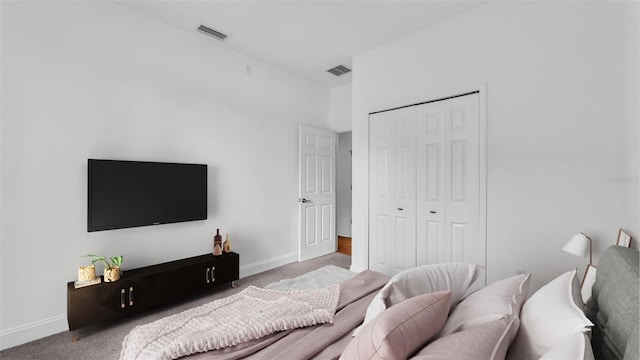 carpeted bedroom with baseboards, visible vents, and a closet