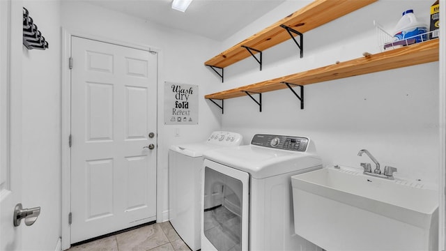 laundry area featuring washing machine and clothes dryer, laundry area, and a sink