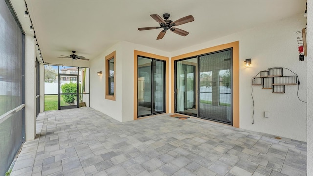 unfurnished sunroom featuring ceiling fan