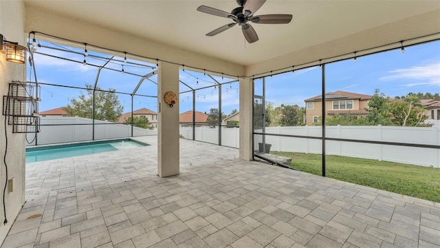 unfurnished sunroom featuring a ceiling fan