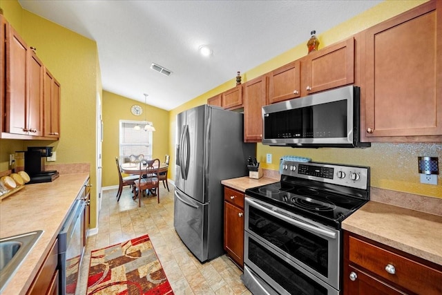 kitchen with visible vents, stainless steel appliances, brown cabinetry, light countertops, and vaulted ceiling