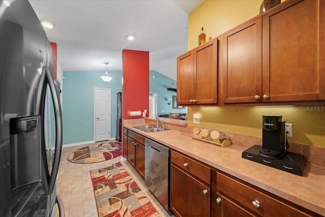 kitchen with baseboards, light countertops, brown cabinets, appliances with stainless steel finishes, and a sink