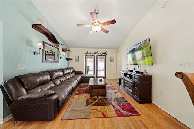 living room with visible vents, light wood-style flooring, baseboards, lofted ceiling, and ceiling fan