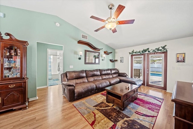 living room with lofted ceiling, french doors, visible vents, and light wood-type flooring