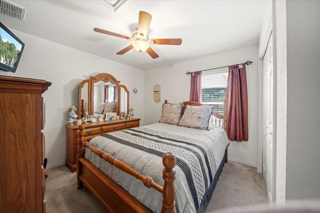 bedroom featuring a ceiling fan, light colored carpet, visible vents, and baseboards