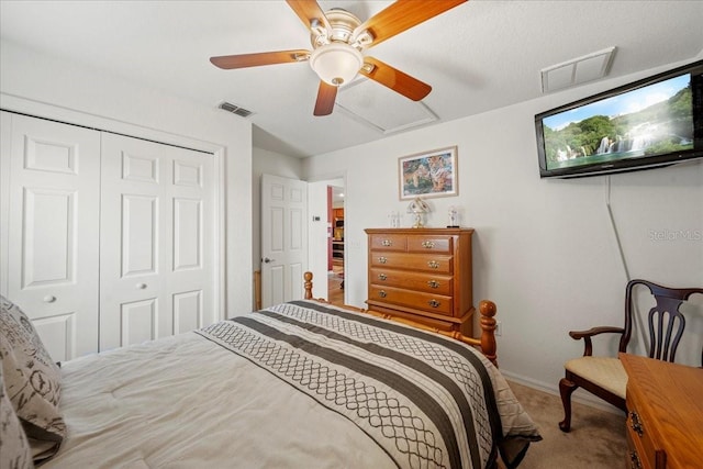 carpeted bedroom with ceiling fan, visible vents, a closet, and attic access