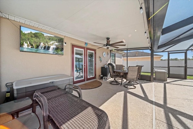 view of patio / terrace with fence, a lanai, french doors, outdoor dining space, and a ceiling fan