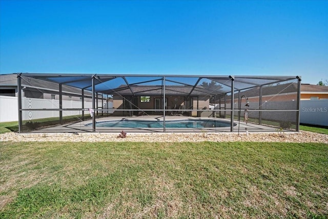 view of swimming pool featuring a yard, a fenced in pool, a lanai, and fence