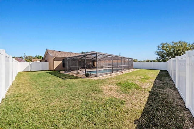 view of yard with glass enclosure, a fenced backyard, and a fenced in pool