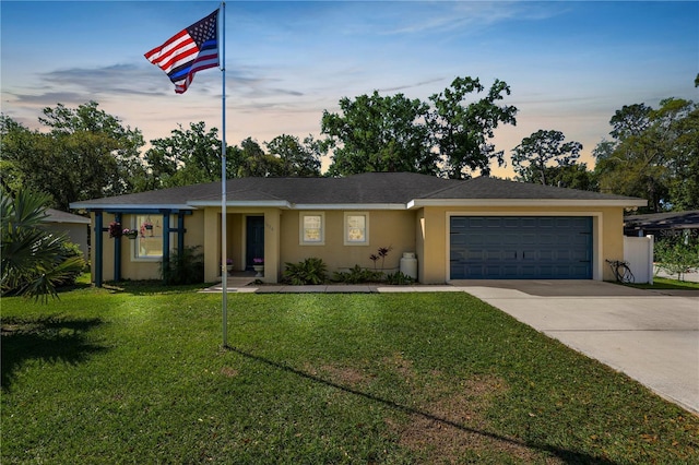 ranch-style home with stucco siding, concrete driveway, a garage, and a front yard