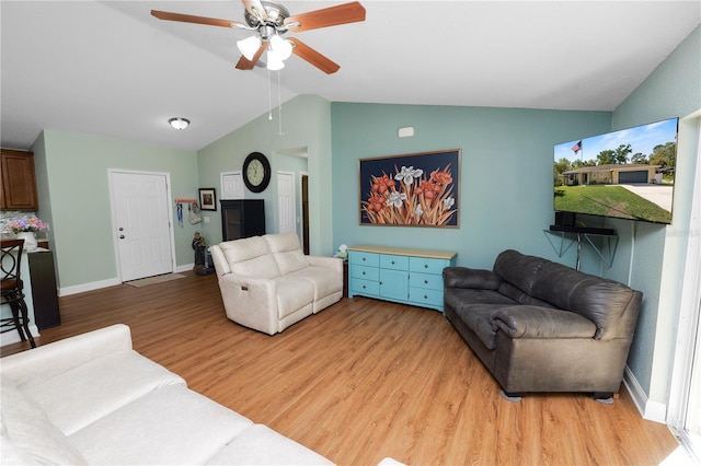 living area featuring ceiling fan, baseboards, lofted ceiling, and light wood-style flooring