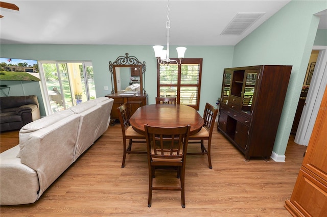 dining space featuring light wood-style flooring, visible vents, and a chandelier