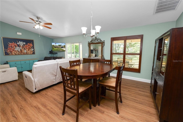 dining area featuring visible vents, baseboards, light wood-style flooring, and vaulted ceiling