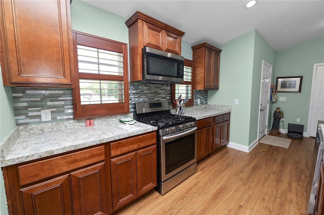 kitchen featuring light countertops, plenty of natural light, light wood-type flooring, and appliances with stainless steel finishes