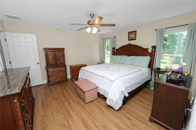 bedroom featuring multiple windows, baseboards, visible vents, and light wood finished floors