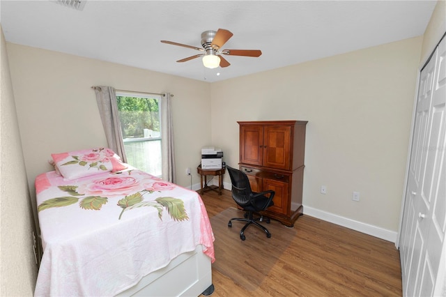 bedroom with light wood-style flooring, baseboards, a closet, and ceiling fan