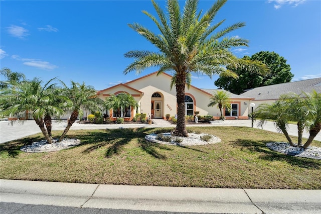 mediterranean / spanish-style house with a front yard and stucco siding