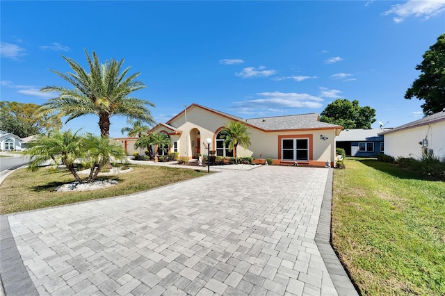 view of front of home with a front yard and stucco siding