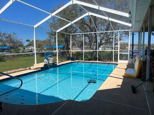 pool featuring glass enclosure and a patio area