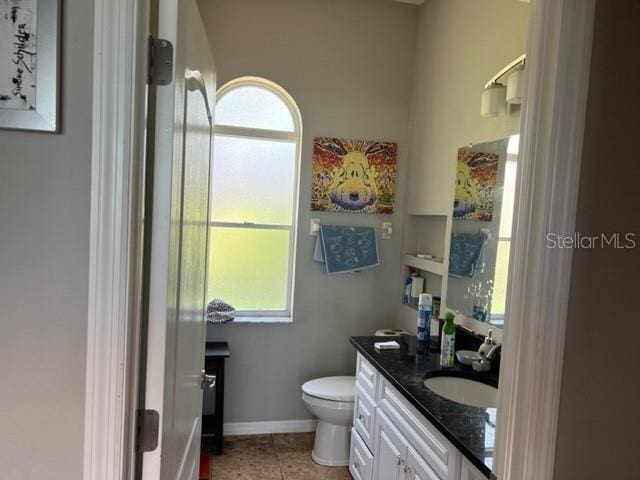 bathroom featuring tile patterned floors, toilet, vanity, and baseboards