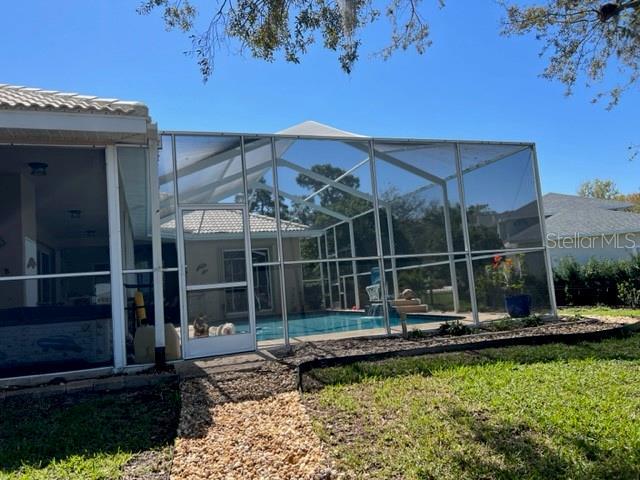 pool with a patio area and glass enclosure