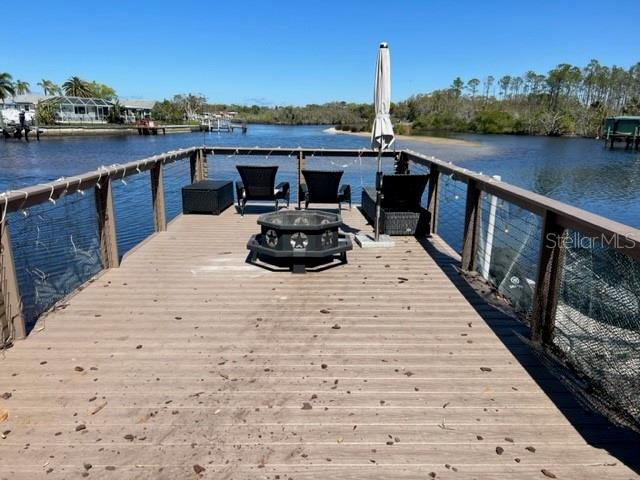 dock area featuring a fire pit and a water view