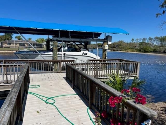 dock area with boat lift and a water view