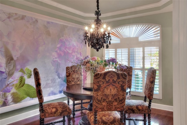 dining room with baseboards, a tray ceiling, ornamental molding, wood finished floors, and a notable chandelier