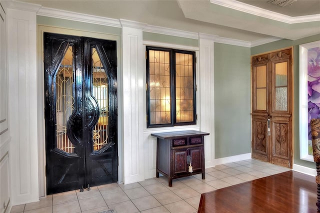 entrance foyer with tile patterned flooring, crown molding, and baseboards