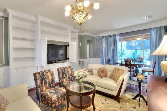 living area with a chandelier, built in features, wood finished floors, arched walkways, and a decorative wall