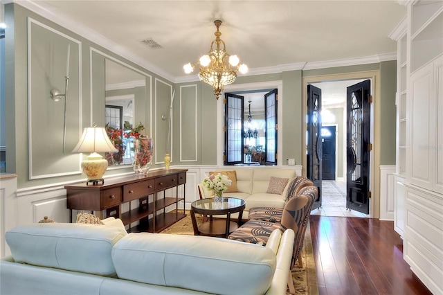 living room with hardwood / wood-style floors, crown molding, a decorative wall, and visible vents