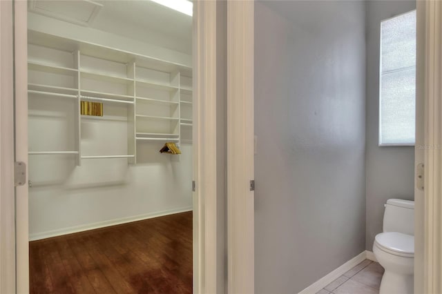 bathroom featuring toilet, baseboards, and wood finished floors