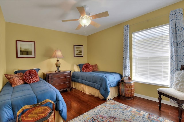 bedroom with ceiling fan, baseboards, multiple windows, and wood finished floors