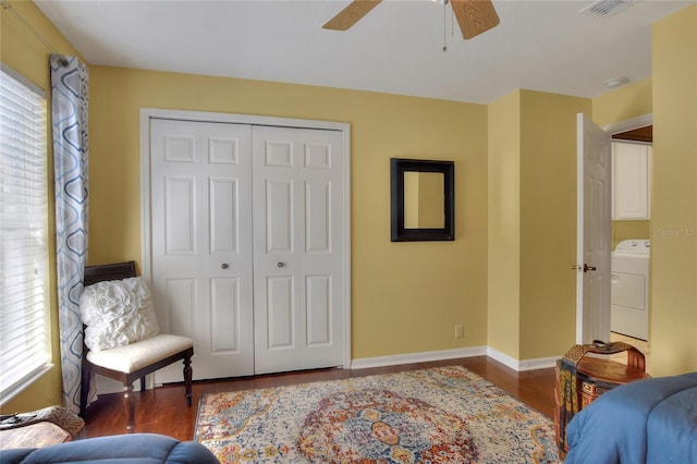 bedroom with visible vents, washer / clothes dryer, wood finished floors, a closet, and baseboards