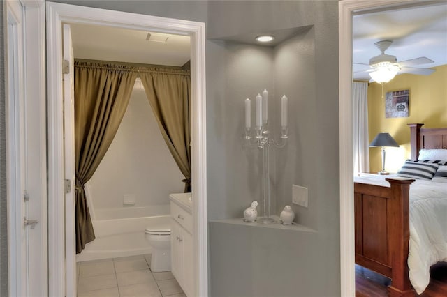 full bath with toilet, shower / tub combo with curtain, tile patterned floors, vanity, and a ceiling fan