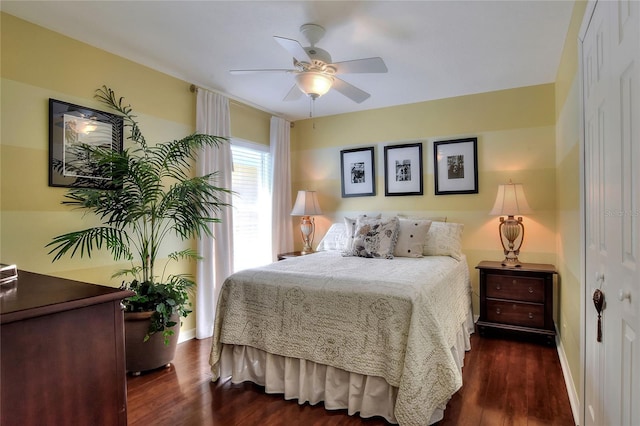 bedroom with a ceiling fan, dark wood-type flooring, and baseboards