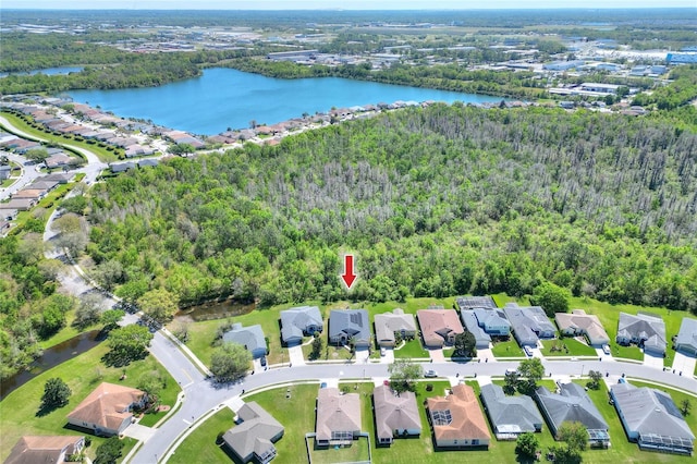 aerial view featuring a forest view, a water view, and a residential view