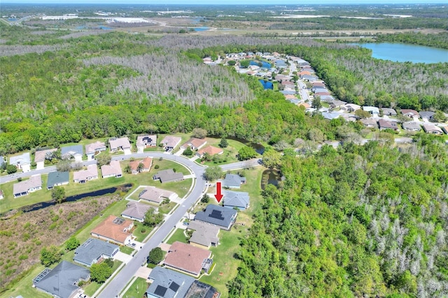 birds eye view of property with a residential view, a view of trees, and a water view