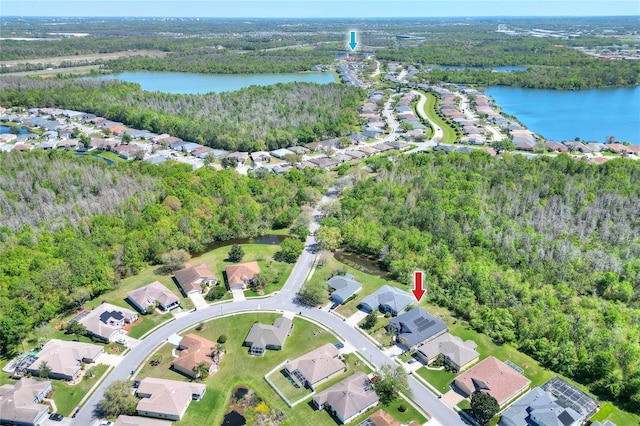 aerial view with a residential view, a water view, and a view of trees