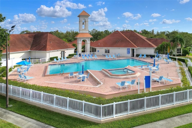 pool with a patio and fence