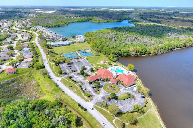 birds eye view of property with a water view and a wooded view