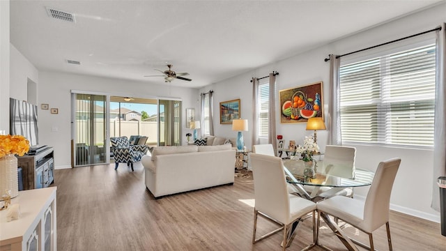 dining area featuring light wood-style floors, visible vents, and baseboards