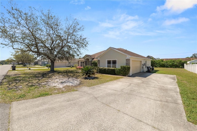 view of front of home with fence, driveway, stucco siding, a front lawn, and a garage