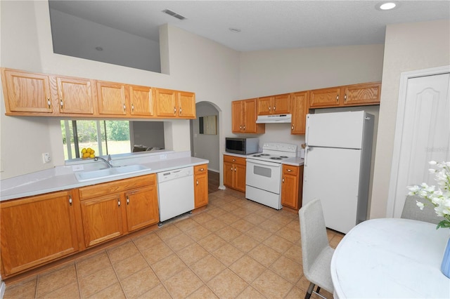 kitchen with white appliances, visible vents, a sink, light countertops, and under cabinet range hood