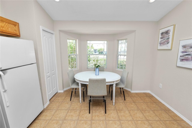 dining area featuring light tile patterned floors and baseboards