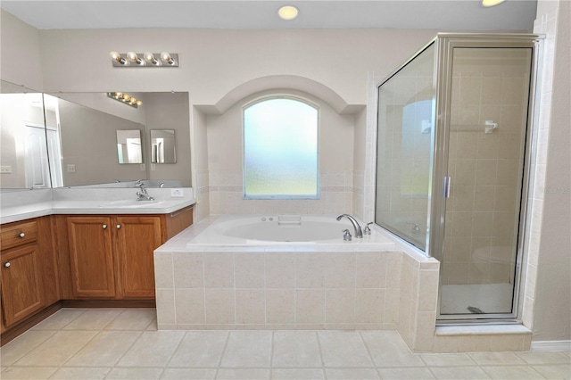 bathroom featuring tile patterned flooring, a stall shower, vanity, and a garden tub