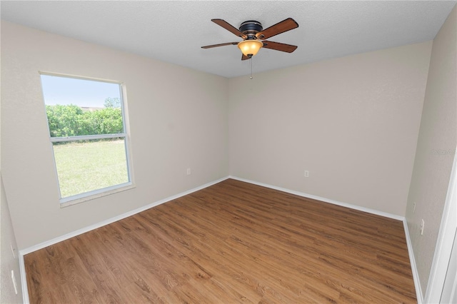 unfurnished room featuring ceiling fan, a textured ceiling, baseboards, and wood finished floors