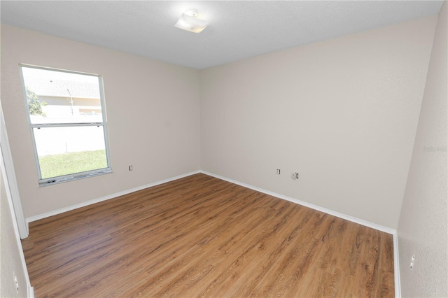 spare room featuring baseboards and light wood-style flooring