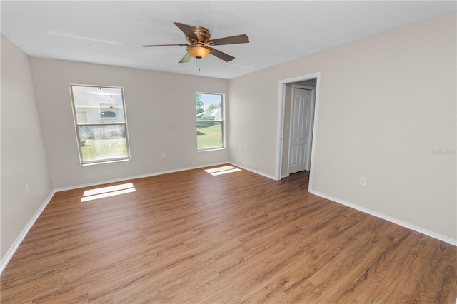 unfurnished room featuring baseboards, a ceiling fan, and light wood-style floors