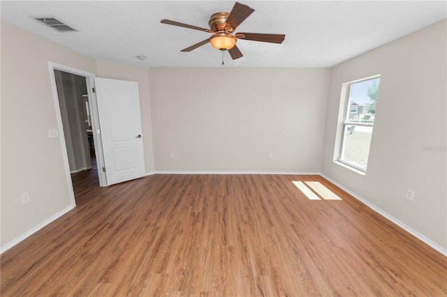 empty room featuring visible vents, baseboards, light wood-style floors, and a ceiling fan